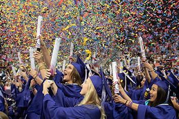 TCU graduates in caps and gowns set off handheld confetti cannons